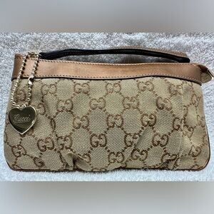 GUCCI Signature Wristlet with Engraved Heart Charm and Bronze Leather Trim.